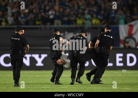 Un ventilatore adorante è azionato fuori dalla sicurezza dei membri del personale durante il 2019 International Champions Cup torneo di calcio tra Juventus F.C. e Inter nella città di Nanjing East cinese della provincia di Jiangsu, 24 luglio 2019. Foto Stock