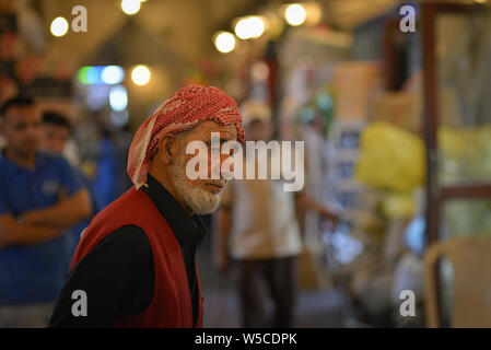 DOHA, Qatar - 27 febbraio 2016: Consegna vecchio lavoratore nel Souq Wakif. Scattata di notte con il flash. Foto Stock