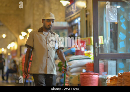 DOHA, Qatar - 27 febbraio 2016: Espatriati lavoratore di pulizia nel Souq Wakif. Scattata di notte con il flash. Foto Stock