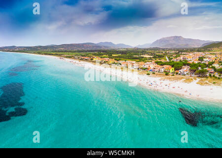 Spiaggia di graniro con azure acqua limpida e La Caletta città, Sardegna, Italia, Europa. Foto Stock