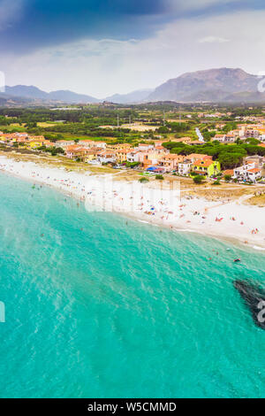 Spiaggia di graniro con azure acqua limpida e La Caletta città, Sardegna, Italia, Europa. Foto Stock