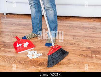 Close-up dei maschi di spazzare il pavimento di legno con una piccola  frusta la scopa e paletta Foto stock - Alamy