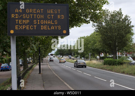 British temporanea cartello stradale di avvertimento di segnali temporanei e previsto ritardi sulla a4 Great West road, a Londra, Inghilterra Foto Stock