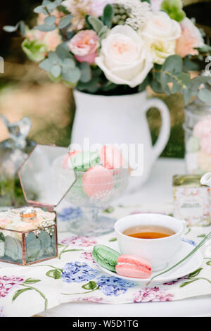 Ancora vita brides mattina, piatto con tazza di tè, bicchiere di champagne, fedi e bouquet di fiori Foto Stock