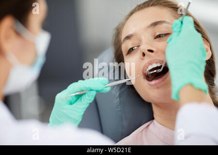 Close up ritratto di giovane e bella donna in poltrona odontoiatrica durante la visita medica di controllo, spazio di copia Foto Stock