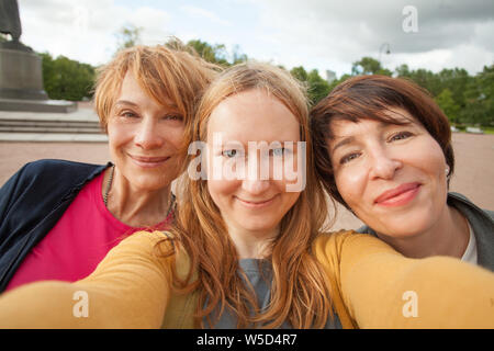 Tre diverse felici donne amici facendo selfie foto e divertimento all'aperto Foto Stock