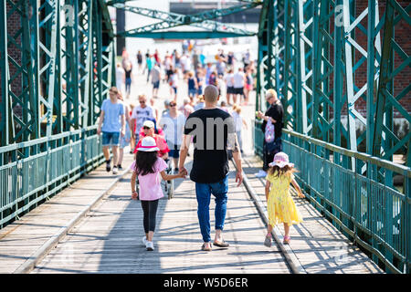 Wilhelmshaven, Germania. 28 Luglio, 2019. Un padre e le sue due figlie attraversare un ponte per le barche DGzRS il giorno del salvataggio in mare dei soccorritori della Deutsche Gesellschaft zur Rettung Schiffbrüchiger. Credito: Mohssen Assanimoghaddam/dpa/Alamy Live News Foto Stock