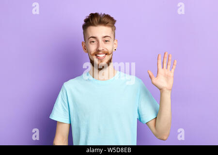 Positivo uomo allegro che mostra il suo aprire palm emozioni umane, le espressioni del viso uomo bello agitando la mano, ciao, ciao, buona sera, vedere di seguito. Foto Stock