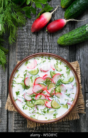 Estate yogurt zuppa fredda con radicchio, cetriolo, e aneto su woodwn table, top view.Okroshka. Foto Stock