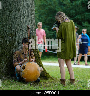 WOMAD Festival, Charlton Park, Wiltshire, Regno Unito. 28 Luglio, 2019. Una donna le riprese di un musicista con un Super 8 telecamera cinematografica al Womad Festival (mondo delle arti di musica e danza) Domenica 28 Luglio 2019 a Charlton Park di Malmesbury. Foto di credito: Julie Edwards/Alamy Live News Foto Stock