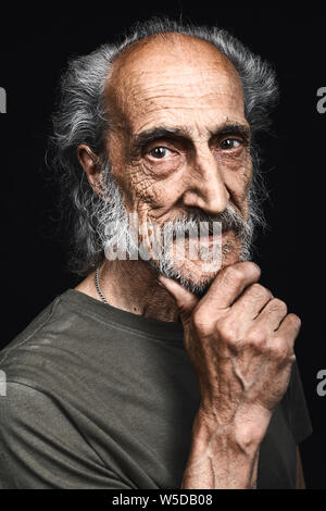 Vecchia persona senza dimora con una mano sul mento pensare al problema, pensieroso espressione.dubbio concetto. l uomo ha un sacco di difficoltà nella vita. studio shot. Foto Stock