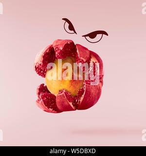 Concetto di succosa frutta fresca. Melograno monster mangia la pesca. Melograno peach mix. Immagine ad alta risoluzione Foto Stock