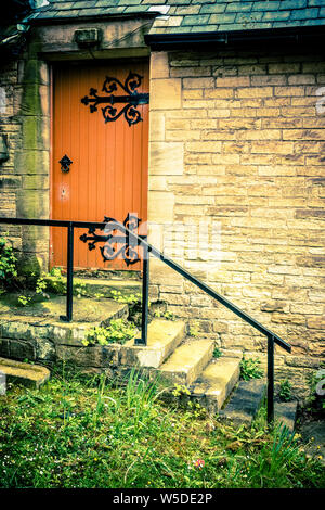 Dipinto di arancione porta laterale ad una chiesa in Consett, County Durham, England, Regno Unito Foto Stock