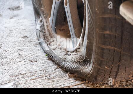 Auto abbandonate il pneumatico sgonfio close-up. Foto Stock