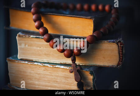 Sul vecchio martoriata Sacre Scritture appendere rosari da perle di legno rosso, come una reliquia sacra Foto Stock