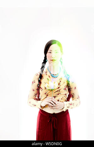 Bella asiatica spirituale coreano donna americana tenendo un bocciolo di loto. Foto Stock