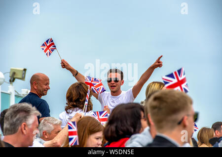 Uomo che conduce la folla, ondeggiando Union Jack Flags Foto Stock