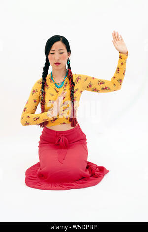 Bella asiatica spirituale coreano donna americana inginocchiato con un espressione rituale espressione. Foto Stock