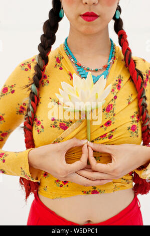 Close-up del raccolto di una bella asiatica spirituale coreano donna americana tenendo un bocciolo di loto. Foto Stock
