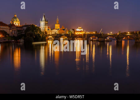 Charles Bridge tra distretti Città Vecchia e Città Minore di notte a Praga. Città vecchia torre e ponte storico in pietra sopra la Moldava illuminazione Foto Stock