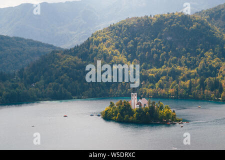 Close up vista aerea dell'isola di Bled sul lago di Bled in Slovenia circondato da montagne e foreste Foto Stock