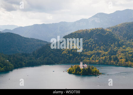 Close up vista aerea dell'isola di Bled sul lago di Bled in Slovenia circondato da montagne e foreste Foto Stock