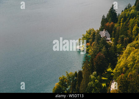 Close up vista aerea della parte del lago di Bled, in Slovenia. Una piccola casa sulla banca circondata da una foresta Foto Stock