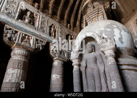 India Maharashtra, Ajanta, grotte di Ajanta. Vista interna di sculture ornate in pietra e soffitti realizzati a guardare come le travi in legno. UNESCO. Foto Stock