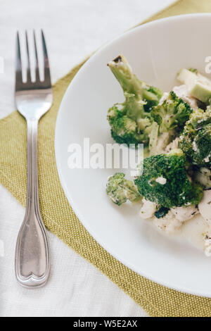Broccoli cotti al forno con pollo su una piastra bianca. Vista superiore, close-up. Una sana e corretta nutrizione Foto Stock