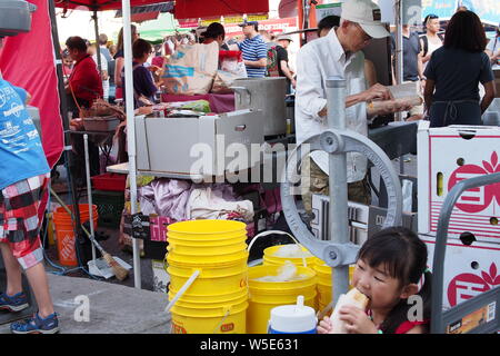 I fornitori di preparare e servire il cibo in Ottawa Asian Fest il Mercato Notturno, 2019. Ottawa, Ontario, Canada. Foto Stock