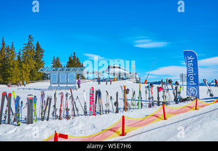 ZELL AM SEE, Austria - 28 febbraio 2019: Gli sportivi lasciava di sci e di snowboard in marcia nella neve attorno a stazione della seggiovia in Areitalm prato alpino, Foto Stock