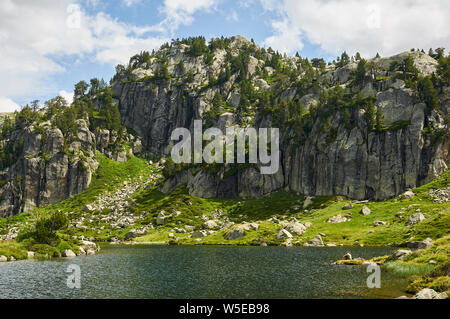 Gli escursionisti in appoggio al piano Estanh lago di Aigüestortes i Estany de Sant Maurici National Park (Valle de Arán, Lleida, Pirenei, Catalogna, Spagna) Foto Stock