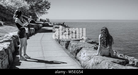 Sul sentiero del Lago Ontario a Niagara sul lago, due giovani donne. Uno prende l'immagine dell'altro. Foto Stock