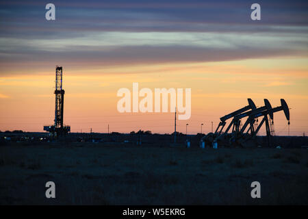 Petrolio e gas Rig e unità di pompaggio al tramonto nel Texas del Sud Foto Stock