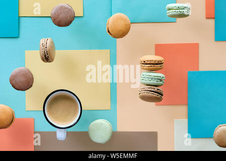 Macarons e expresso, piatto adagiare sulla carta geometrica sfondo in colori pastello Foto Stock