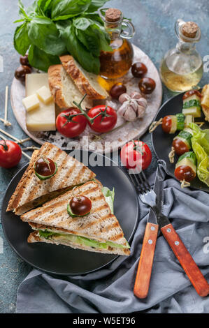 Toast con uova strapazzate, verdure e formaggi. Pomodori e spezie. La deliziosa prima colazione o uno spuntino. Colpo verticale Foto Stock