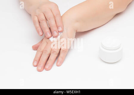 Una donna anziana si applica la crema sulla pelle problematica delle mani da irritazione e arrossamento della pelle, crema con vitamina per le mani, der Foto Stock