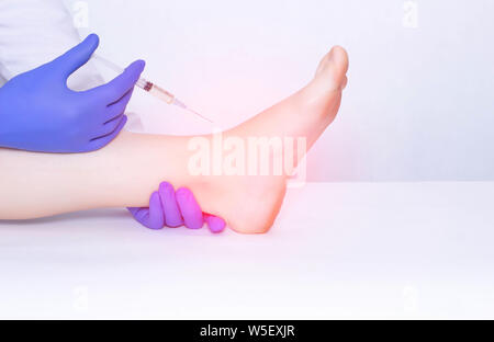 Il medico fa una iniezione nell'articolazione della caviglia del paziente in terapia con plasma per eliminare l'infiammazione e dolore, alleviare edema, spazio copia, OST Foto Stock