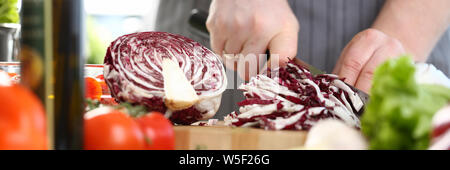 Maschio professionale Chef Chopping cavolo viola Foto Stock