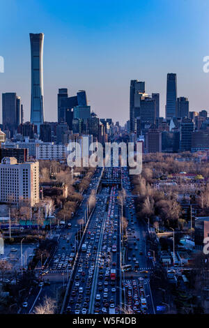 Una vista notturna delle strade trafficate con le masse dei veicoli di fronte al CITIC Tower e altri grattacieli in CBD (Central Business District) in bei Foto Stock