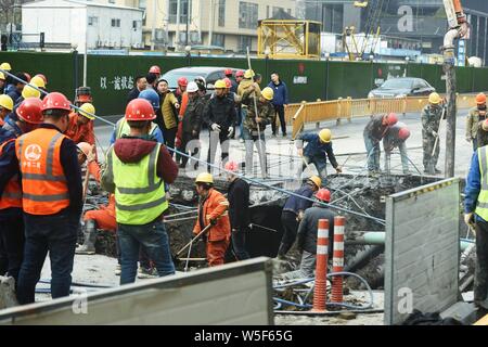 Lavoratori cinesi verificare la continua perdita di tubazioni di acqua causando il crollo della strada su una strada di Hangzhou, a est della Cina di provincia dello Zhejiang, 7 Ma Foto Stock