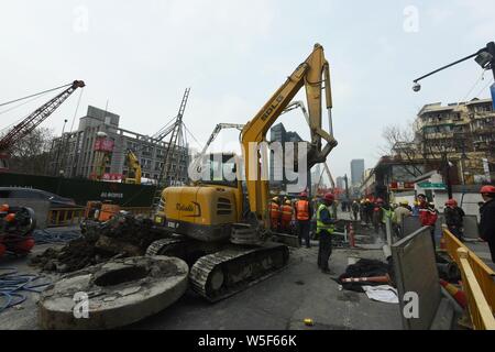 Lavoratori cinesi verificare la continua perdita di tubazioni di acqua causando il crollo della strada su una strada di Hangzhou, a est della Cina di provincia dello Zhejiang, 7 Ma Foto Stock