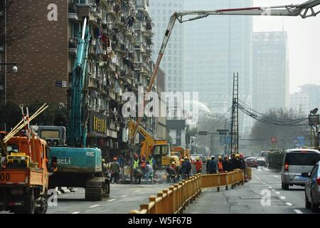 Lavoratori cinesi verificare la continua perdita di tubazioni di acqua causando il crollo della strada su una strada di Hangzhou, a est della Cina di provincia dello Zhejiang, 7 Ma Foto Stock