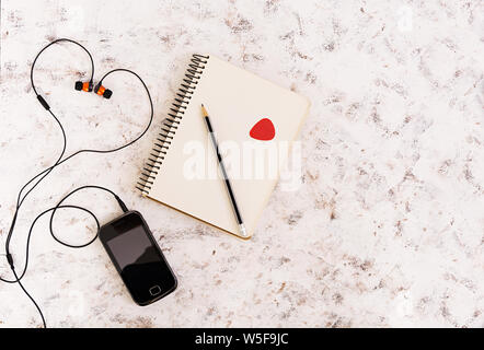 Notebook con il concetto di musica su sfondo bianco. Vista superiore Foto Stock