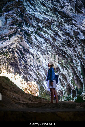 Giovane donna in grotte di Artà (calette d'Artà) nel comune di Capdepera, nel nord-est dell'isola di Mallorca, Spagna Foto Stock