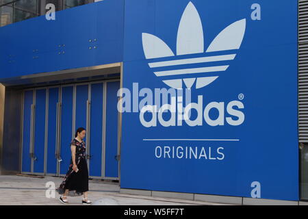--FILE--un residente locale passeggiate passato un annuncio per Adidas a Chongqing Cina, 28 agosto 2018. Adidas ha aumentato la sua moneta-regolati t annuale Foto Stock