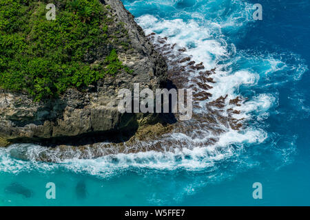 Vertiginoso, vorticoso acqua schiumosa onde ocean fotografata da sopra cliff. Foto Stock