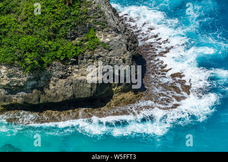 Vertiginoso, vorticoso acqua schiumosa onde ocean fotografata da sopra cliff. Foto Stock