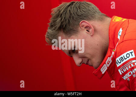 Hockenheim, Germania. 27 Luglio, 2019. Motorsport: il Campionato del Mondo di Formula 1, il Gran Premio di Germania. Mick Schumacher, Formula 2 driver, sta prendendo il suo casco off dopo un ciclo di marcia oltre l'Hockenheimring in un box Ferrari in auto di suo padre del Campione del Mondo di Formula 1 di Schumacher. Credito: Sebastian Gollnow/dpa/Alamy Live News Foto Stock