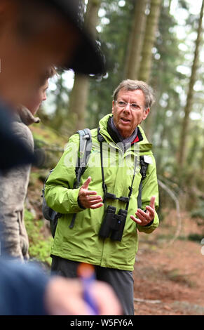 28 maggio 2019, Baden-Wuerttemberg, Seebach: Meinrad Heinrich, ranger di volontariato nella foresta nera Parco Nazionale, porta un gruppo di trekking attraverso la Foresta Nera vicino a Ruhestein. Foto: Uli Deck/dpa Foto Stock